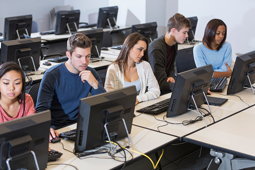 Deelnemers oefenen zelfstandig achter een computer tijdens een cursus