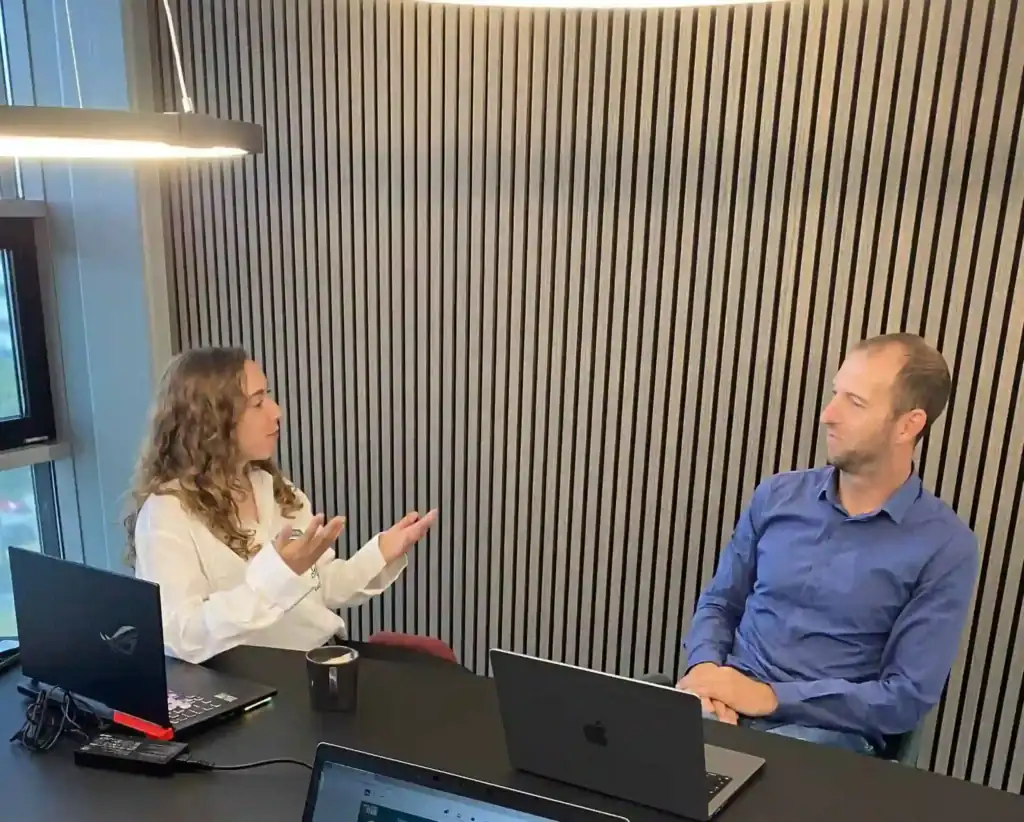 Trainer en deelnemer in gesprek achter een laptop